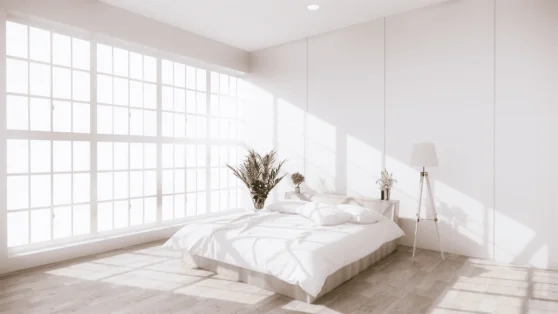 a white bedroom with a bed and plants